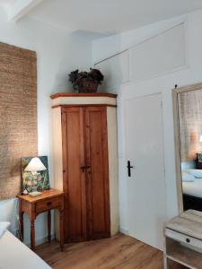 a bedroom with a wooden door and a table at Le Cerisier in Mareil-Marly