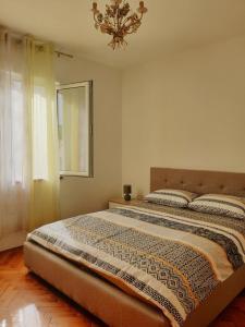 two beds in a bedroom with a chandelier at Apartman Krivokapic in Igalo