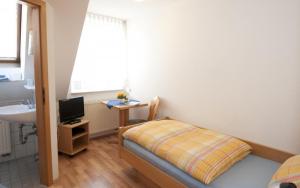 a small bedroom with a bed and a sink at Landgasthof Sonne in Unlingen