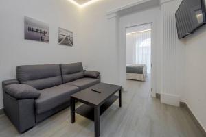 salon z kanapą i stołem w obiekcie SUARA Apartamentos 2 w Madrycie