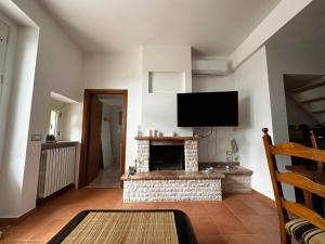 a living room with a fireplace and a flat screen tv at Maison dei Trulli in Locorotondo