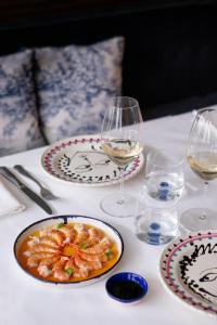 - une table avec des assiettes de nourriture et des verres de vin dans l'établissement Maison Delano Paris, à Paris
