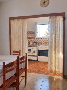 a kitchen with a table and a stove and a window at Apartman Krivokapic in Igalo