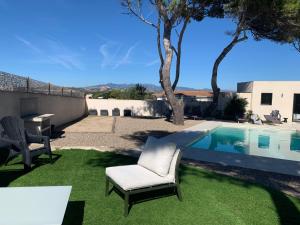 a yard with a chair and a swimming pool at Villa Laricio in Bonifacio