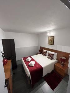 a bedroom with a large bed with a red blanket at Alojamento Rio Neiva in Boticas