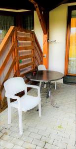 una mesa y dos sillas blancas sentadas en un patio en Michels Apartment en Titisee-Neustadt