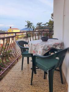 une table et des chaises assises sur un balcon dans l'établissement Apartman Krivokapic, à Igalo