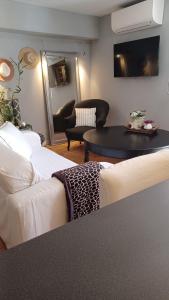 een woonkamer met twee witte banken en een tafel bij Studio de charme avec jardin privatif à 10 minutes des plages in Le Beausset