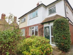 a brick house with a green door and bushes at Cheriton in Tuxford