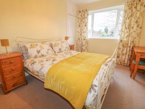1 dormitorio con 1 cama con edredón amarillo y ventana en Cheriton en Tuxford