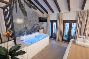 a bathroom with a large tub in a room with windows at Vitium Córdoba in Córdoba