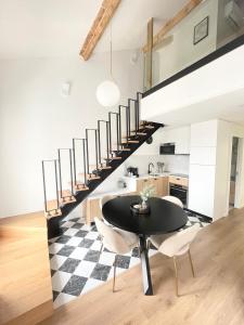 a kitchen and dining room with a black table and chairs at Les Appartements de l'Orangerie in Versailles