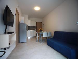 ein Wohnzimmer mit einem blauen Sofa und einer Küche in der Unterkunft Elegant apartment near the beach-Beahost Rentals in Rosolina Mare