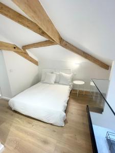 a bedroom with a white bed and a glass table at Les Appartements de l'Orangerie in Versailles