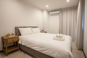 sypialnia z dużym białym łóżkiem i oknem w obiekcie Bangsaray vacation 1 w mieście Bang Sare