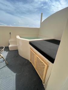 una vasca da bagno seduta sul lato di una barca di BlackRock suites a Karterados