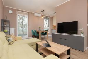 sala de estar con sofá, TV y mesa en Active City Apartments Warsaw by Renters, en Varsovia