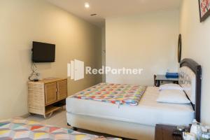 ein Schlafzimmer mit 2 Betten und einem TV in der Unterkunft Javenir Hotel Tawangmangu Mitra RedDoorz in Karanganyar