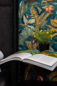 un libro abierto sentado en una mesa con una planta en Active City Apartments Warsaw by Renters, en Varsovia