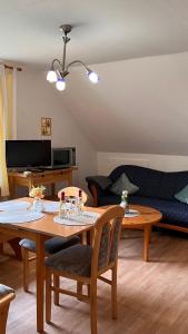 een woonkamer met een tafel en een bank bij Buschhof Albers in Neuharlingersiel
