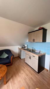 een keuken met een wastafel en een bank in een kamer bij Buschhof Albers in Neuharlingersiel