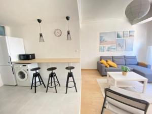 a kitchen and a living room with a blue couch at VibesCoruña- Ferrol 1D in Ferrol