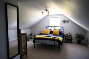 a bedroom with a bed with yellow pillows on it at The Coach House at Wenvoe Manor, Cardiff in Wenvoe