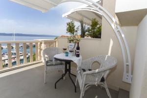 a table and chairs on a balcony with a view of the ocean at Apartments & Room Vesna in Brela