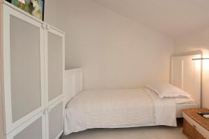 a white bedroom with a bed and a closet at Apartments & Room Vesna in Brela +14 photos