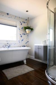 a bathroom with a bath tub and a window at The Coach House at Wenvoe Manor, Cardiff in Wenvoe
