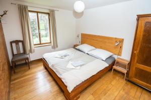 a bedroom with a bed and a chair and a window at Gut Hornegg in Preding