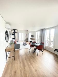 a large living room with a table and chairs at Les Appartements de l'Orangerie in Versailles