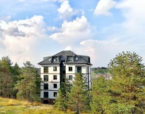 a house on top of a hill with trees at Apartman Ekvilibrijum in Zlatibor