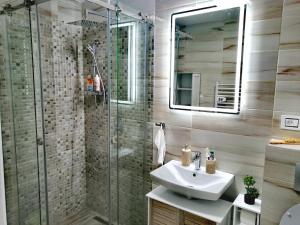 a bathroom with a sink and a glass shower at Apartman Ekvilibrijum in Zlatibor +30 photos