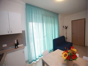 een woonkamer met blauwe gordijnen, een tafel en een blauwe stoel bij Modern two-room seaview apartment - Beahost in Rosolina Mare