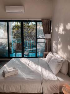 un grande letto in una camera da letto con una grande finestra di Lugo Hotel a Manzhou