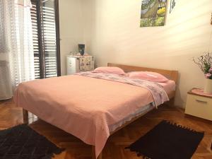 - une chambre avec un lit et une couverture rose dans l'établissement Apartments Ljubica, à Rovinj