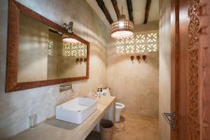 a bathroom with a sink and a mirror at Villa Tulia in Matemwe
