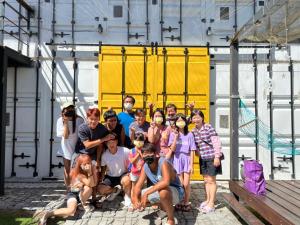 un grupo de personas posando para una foto frente a un edificio en 20ft Sea Attic, en Isla Verde