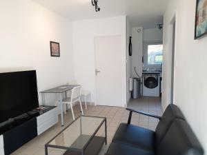 uma sala de estar com um sofá e uma mesa em Ty Cocoon- Appartement avec terrasse et parking privé em Quimper