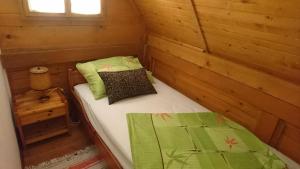a small room with a bed in a log cabin at Apartmani Dada Kanjon Grmuša in Bihać