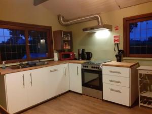 索姆勒茲的住宿－Chalet Nutons，厨房配有白色橱柜和炉灶。