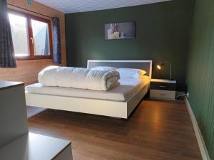 索姆勒茲的住宿－Chalet Nutons，一间卧室配有一张带白色床单的床和一扇窗户。