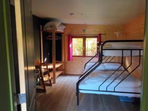 een kamer met 2 stapelbedden en een raam bij Chalet Nutons in Somme-Leuze