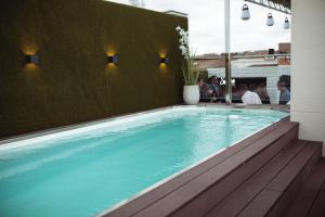 a hot tub in a room with a green wall at Hotel GilMar Orellana la Vieja in Orellana la Vieja