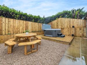 d'une terrasse avec une table et une télévision sur une clôture. dans l'établissement Heathcote Hideaway - Uk36659, à Hartington