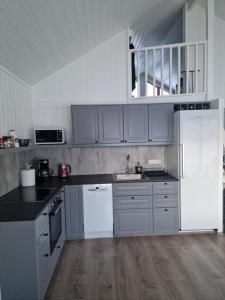 una cocina con electrodomésticos blancos y armarios grises en Cottage - two bedrooms, en Blönduós