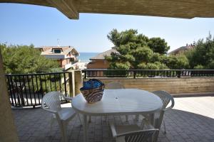 un tavolo bianco e sedie su un balcone con vista sull'oceano di Residence Adriatico a Silvi Marina