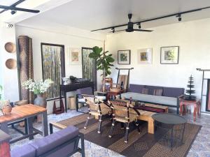 a living room with a couch and tables and chairs at Moonlight Champa Riverview in Luang Prabang