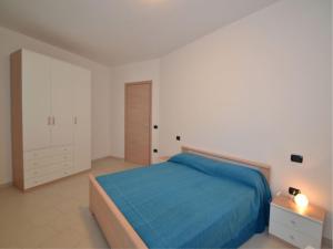 een slaapkamer met een blauw bed en een nachtkastje bij Modern flat in central location in Rosolina Mare in Rosolina Mare